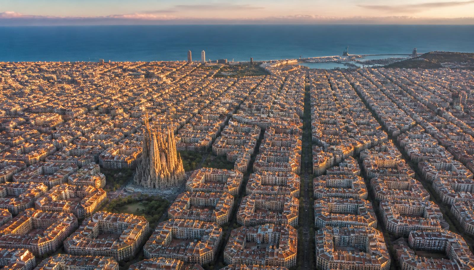 Vista aérea de Barcelona al atardecer con la Sagrada Familia y el Mediterráneo